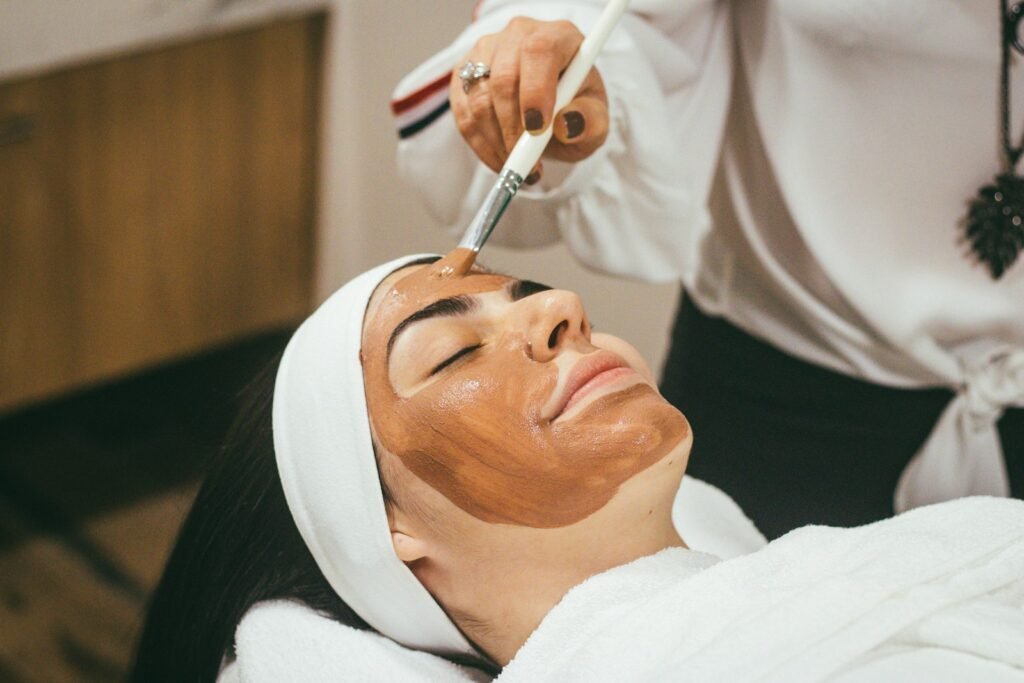 Klant krijgt een gezichtsmasker in de salon