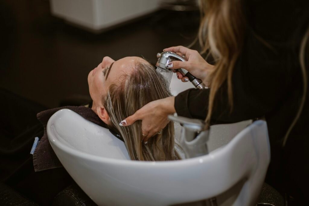 Klant krijgt een haarwasbeurt in de salon